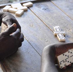 manos de jamaiquinos jugando dominó