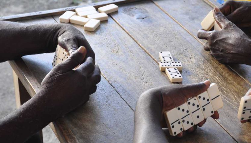 manos de jamaiquinos jugando dominó