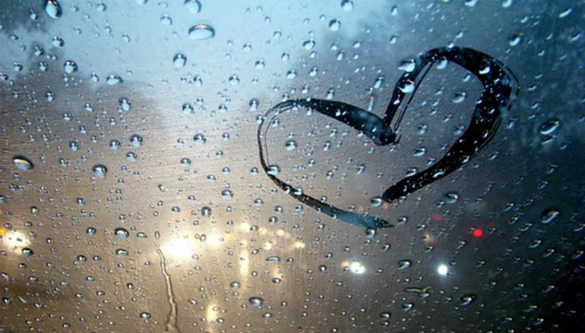 ventana empañada de lluvia y un corazón dibujado