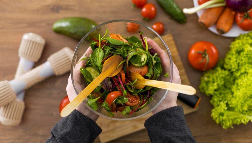 bowl de vidrio con verduras y cucharas de madera